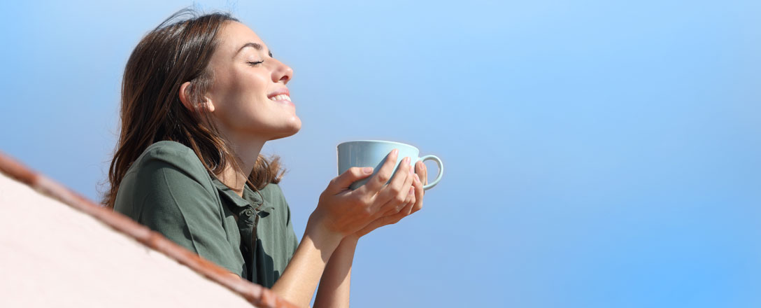 Frau genießt Kaffee in der Sonne