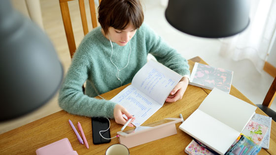 Teenager macht Hausaufgabe am Küchentisch