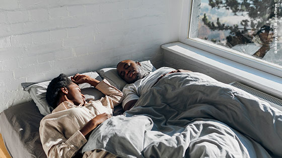 Paar liegt gemeinsam im Winter im Bett