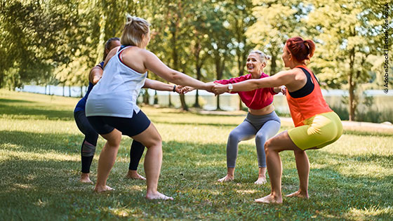 Eine Gruppe von Freund:innen bewegt sich gemeinsam im Sommer draußen