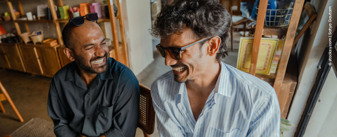 Zwei Männer lachen in einem Café