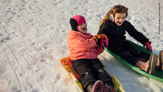Kinder rodeln im Winter