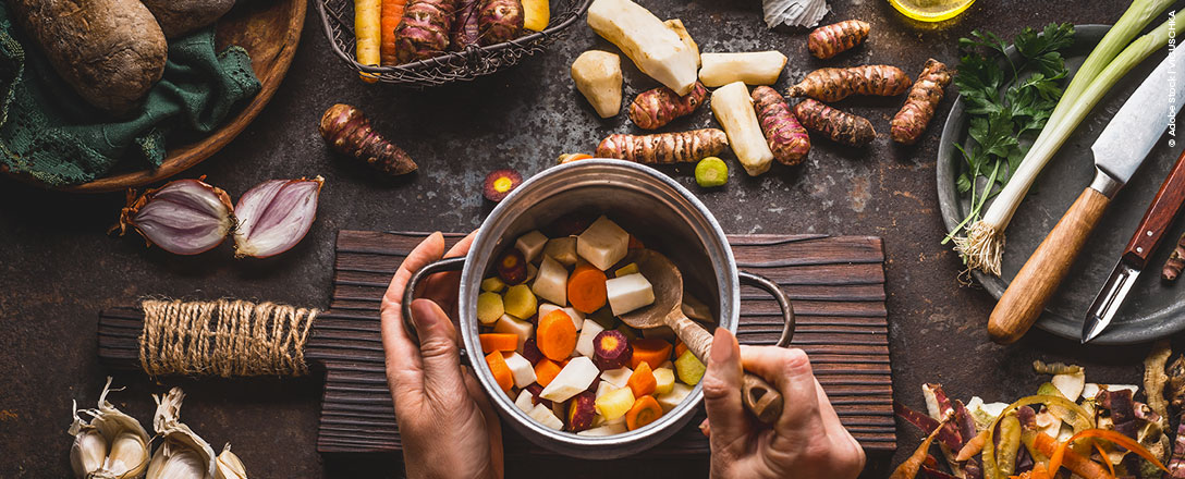 Frau schneidet Gemüse in der Küche