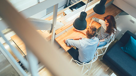 Paar sitzt an Holz-Tisch in Wohn-Ess-Zimmer