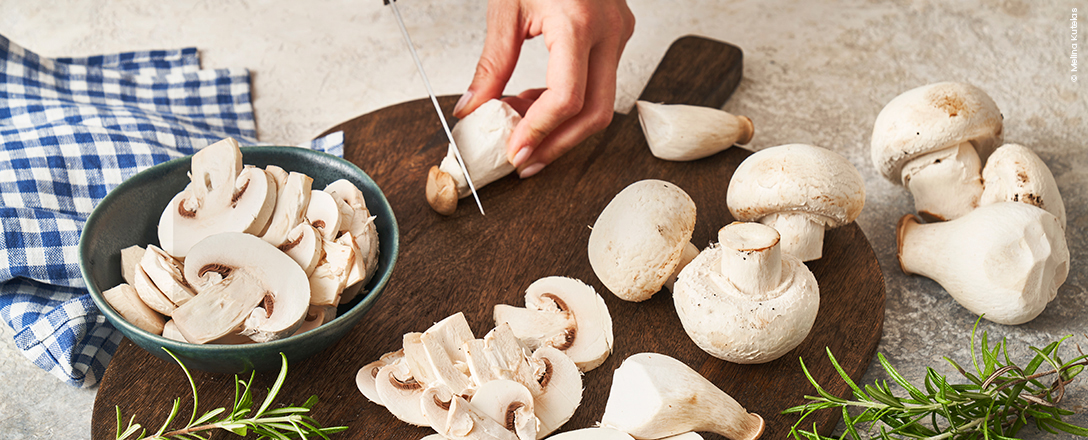 Holzbrett mit Champignons und Kräuterseitlingen