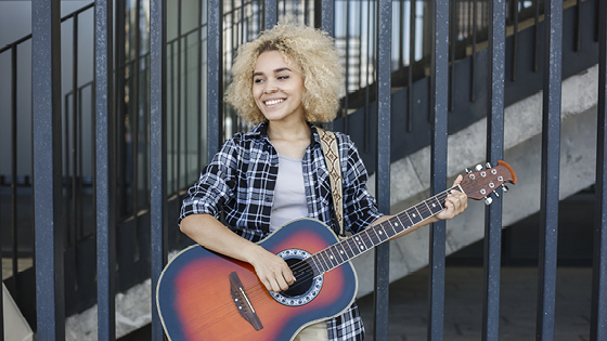 Junge Frau spielt auf einer Westerngitarre
