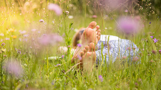 Fußsohlen in einer Blumenwiese
