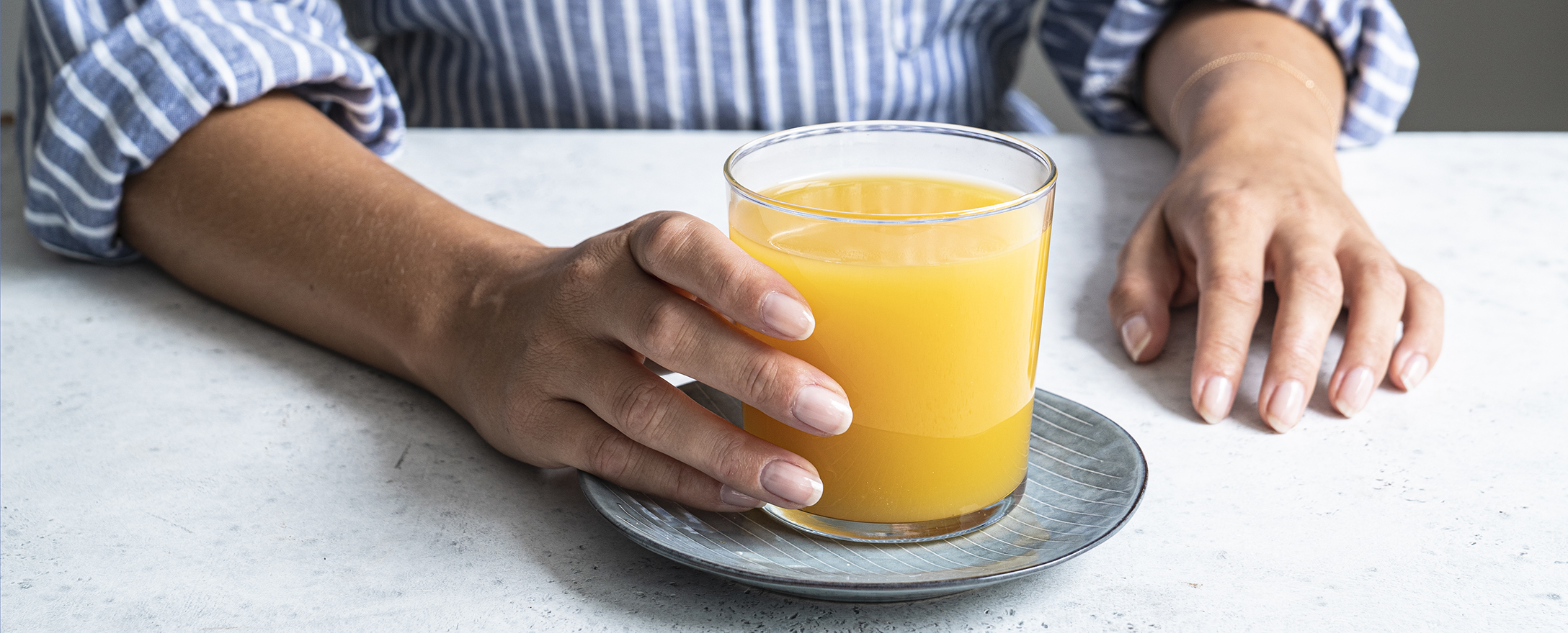 frau in blauem hemd mit orangensaft