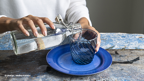 Eine Falsche und Glas mit Mineralwasser