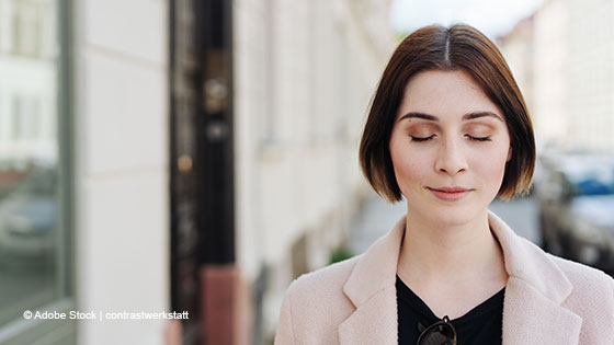 Frau geht mit geschlossenen Augen