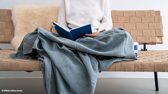 frau liest buch auf couch