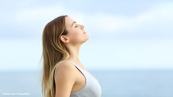 Frau steht und Atmet ein 