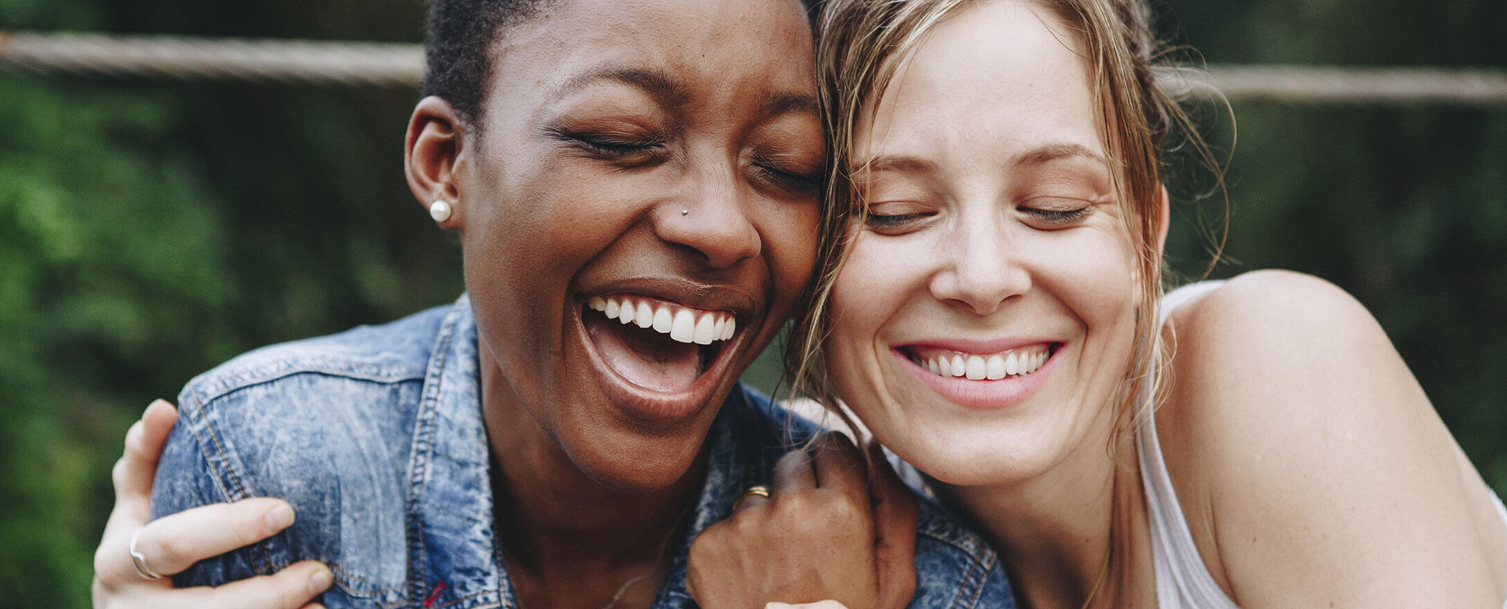 zwei Frauen halten sich und lachen
