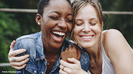 zwei Frauen drücken sich und lachen 