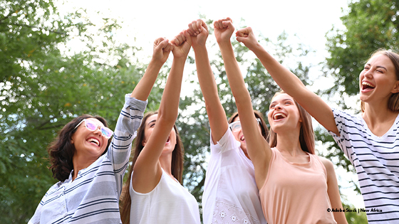 Frauen strecken ihre Arme aus und bilden eine Faust