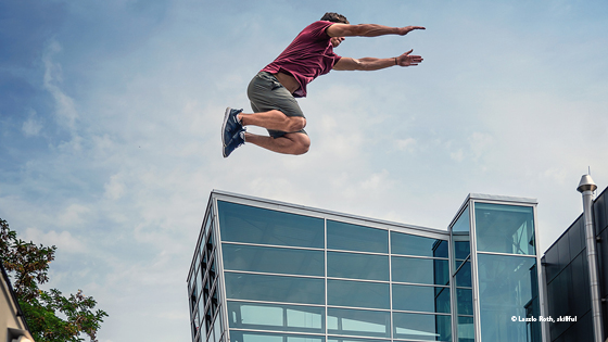 Mann springt über Haus
