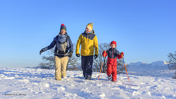 Familie geht im Schnee spazieren