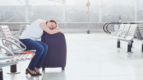 Frau schläft auf dem Koffer