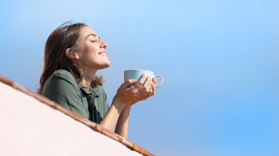 Frau genießt Kaffee in der Sonne