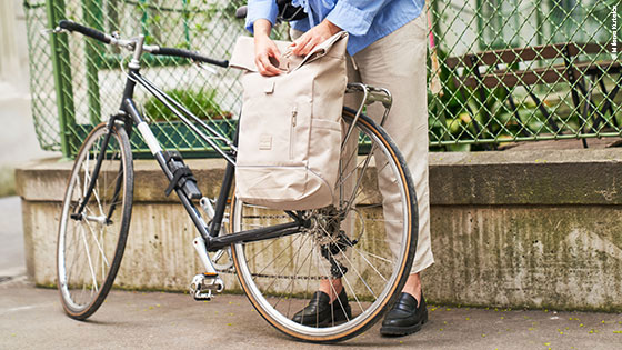 Person befestigt beige Satteltasche am Fahrrad