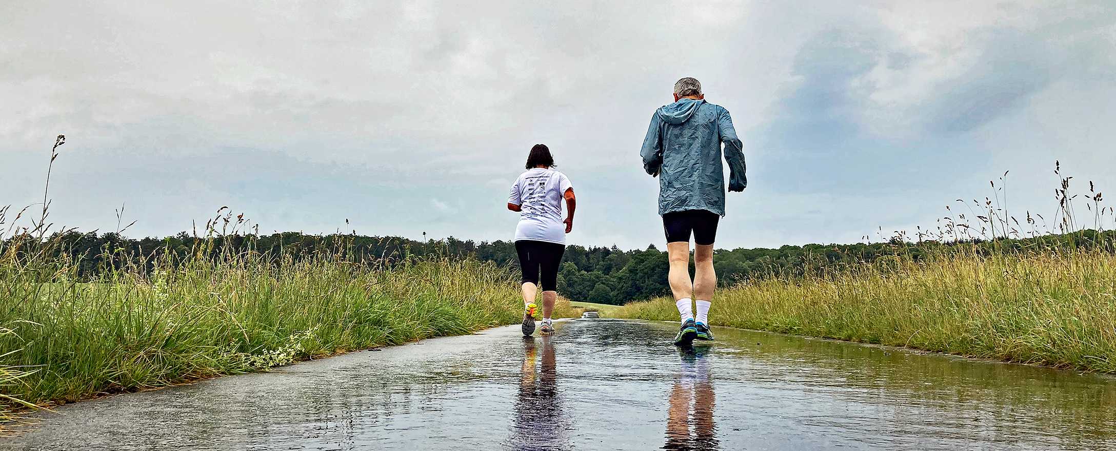 2 personen joggen im regen