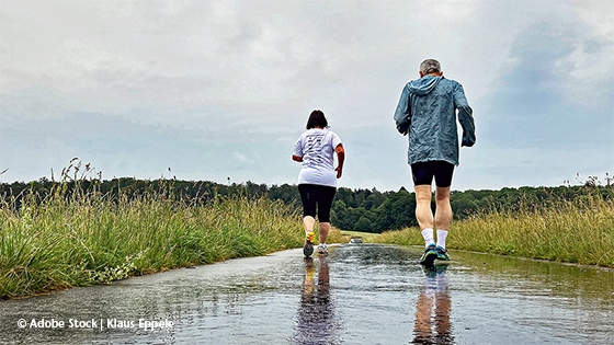 zwei personen joggen bei regen