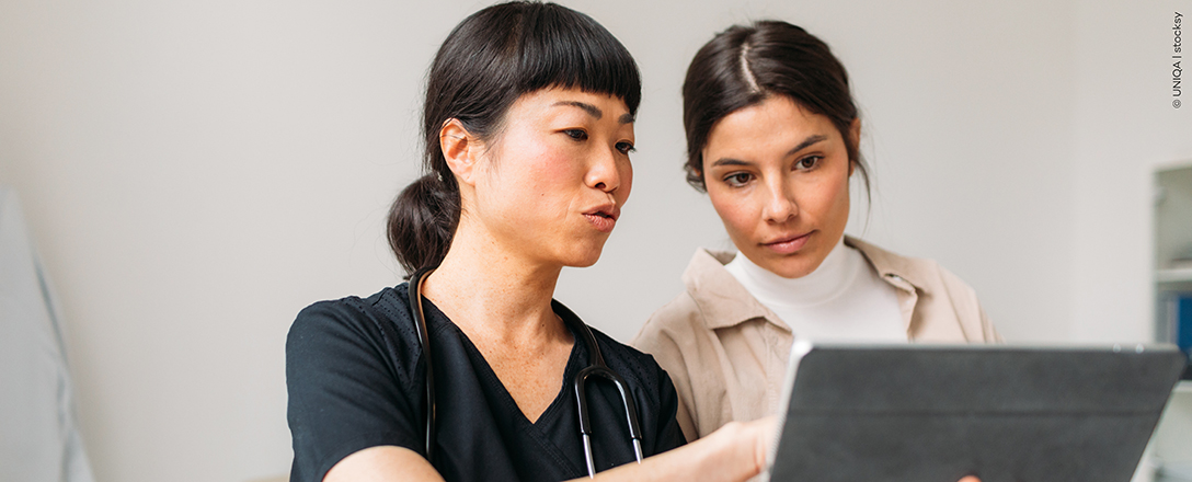 Eine Frau und eine Ärztin schauen gemeinsam auf ein Tablet