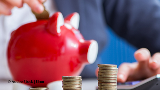 Geld sparen in einem roten Sparschwein