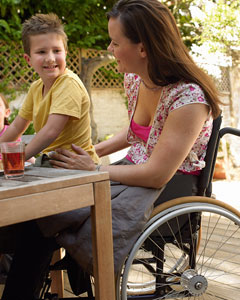 Frau im Rollstuhl mit Kind an ihrer Seite