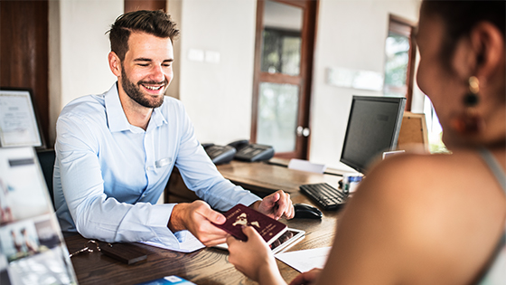 Mann übergibt Dokument an Frau an Schreibtisch