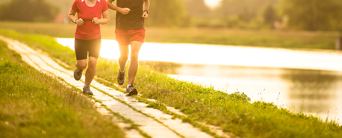 Läuferin  und Läufer im Sommer am Wasser