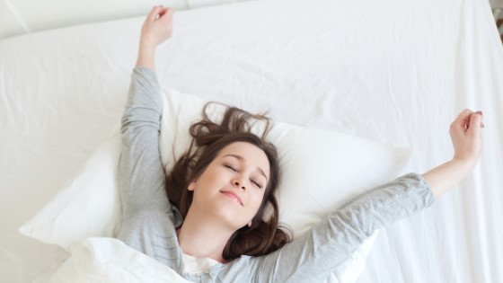 Frau streckt sich im Bett