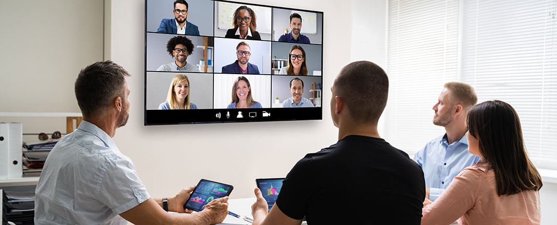 Menschen im Büro und auf Bildschirm bei Meeting