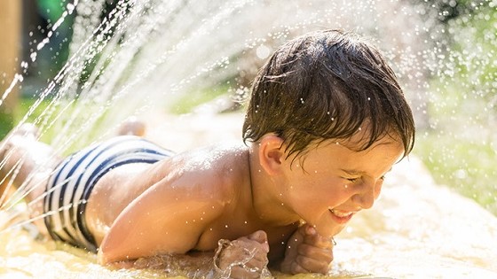 Junge beim Planschen im Garten