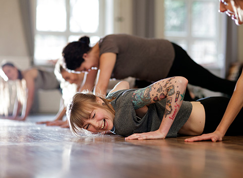 Junge Frau lachend im Fitnesskurs