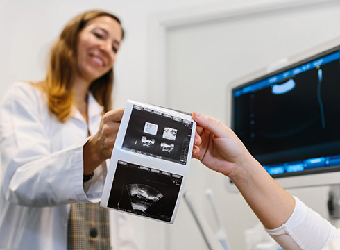 Ärztin hält Ultraschallbilder