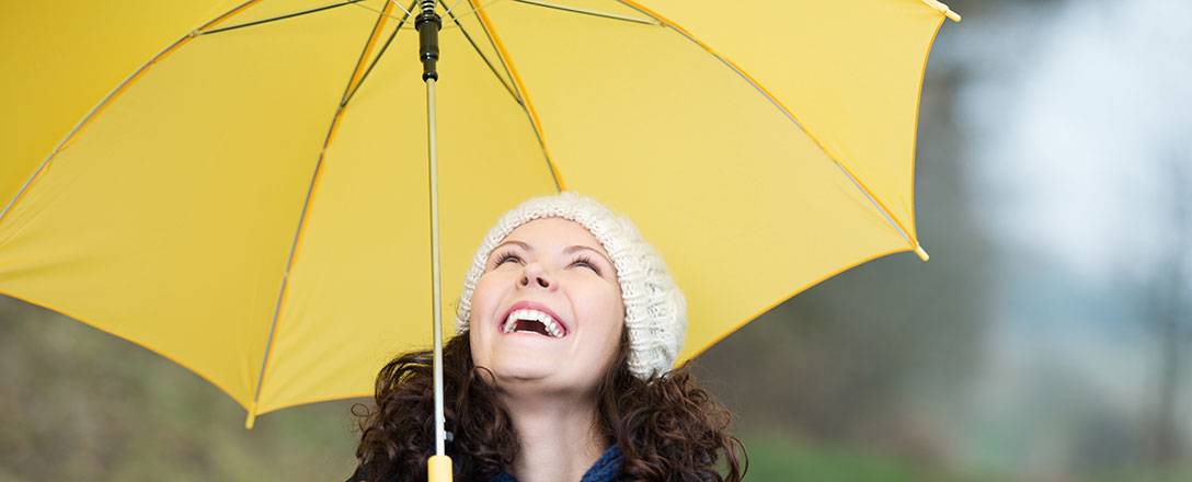 Lachende Frau unter Regenschirm
