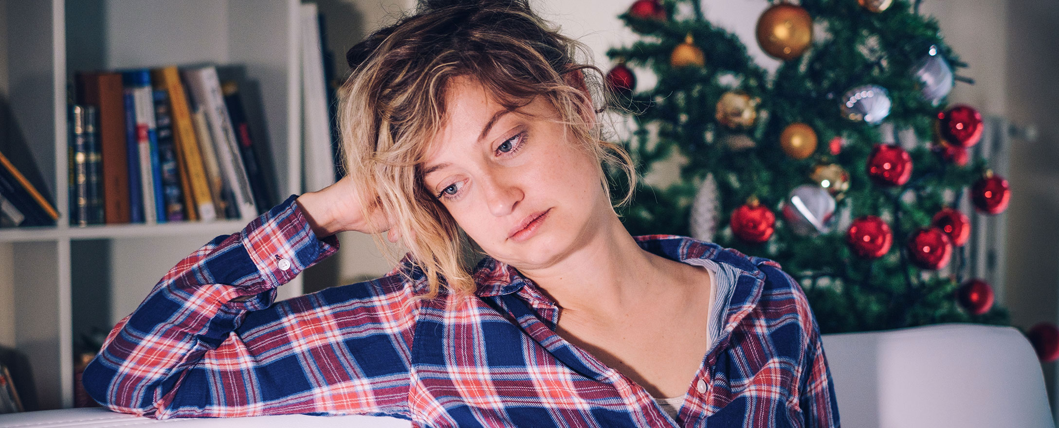 Traurige Frau vor Christbaum