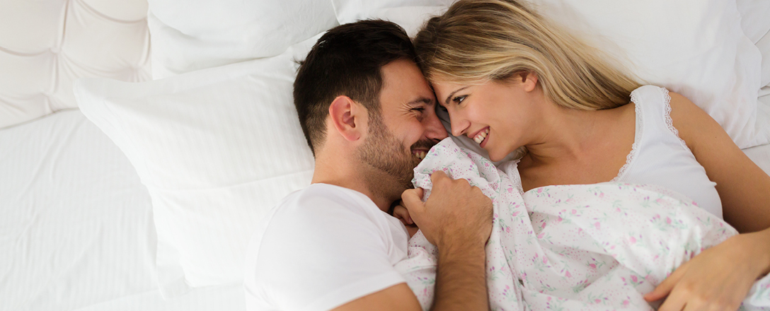 Mann und Frau zugedeckt im Bett