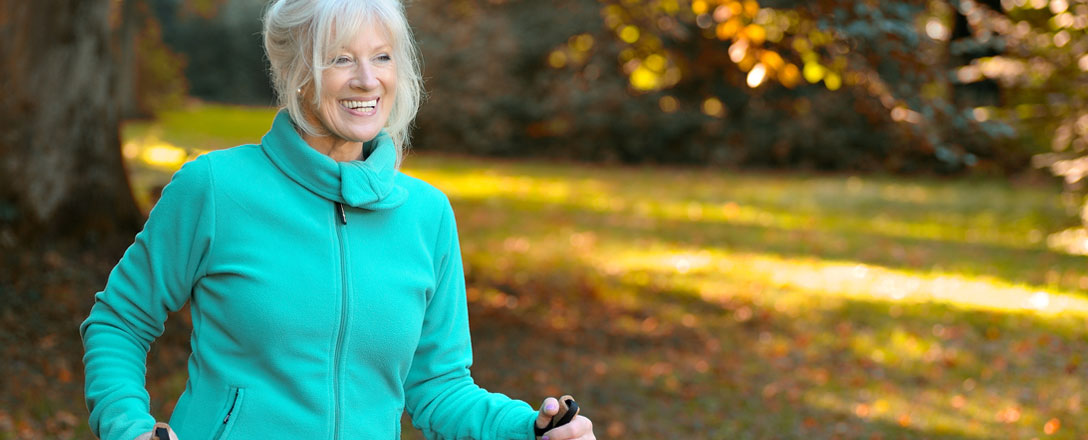 Seniorin beim Nordic Walking