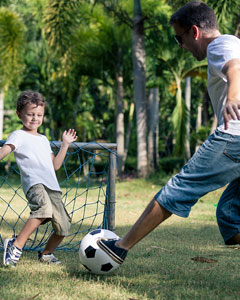 Vater mit kleinem Sohn beim Fussball spielen