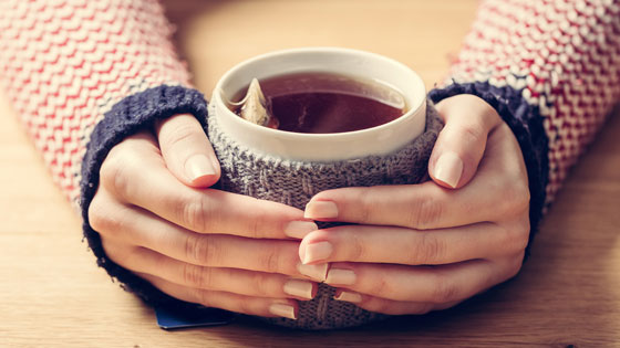 Frau mit Tee in den Händen.