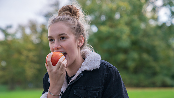 Junge Frau ist einen Apfel