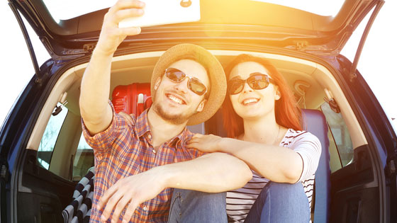 Junges Paar im Kofferraum macht Selfie