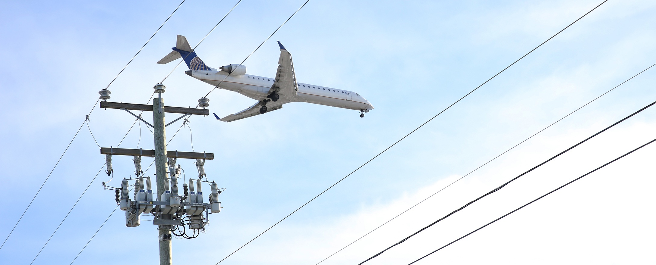 Flugzeug, Strommast und Stromkabel