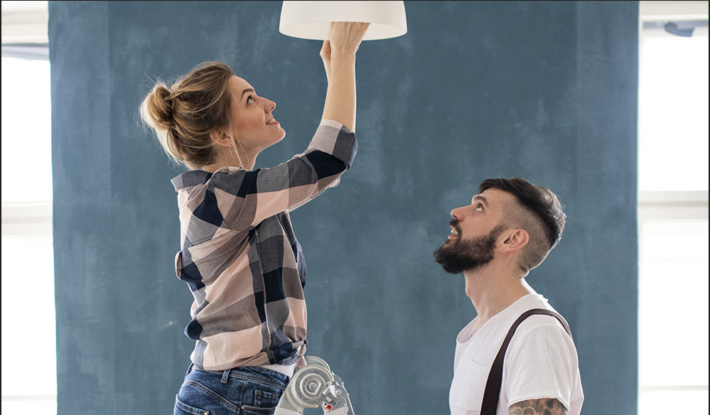 Paar tauscht Glühbirne im Wohnzimmer