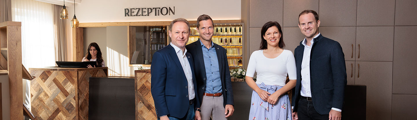 4 Personen vor Hotelrezeption