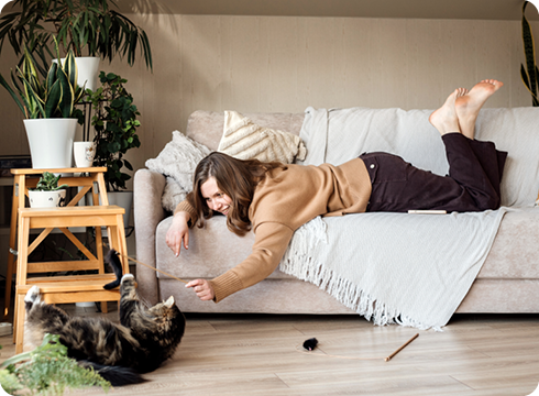 Frau sitzt mit Katze auf Armsessel
