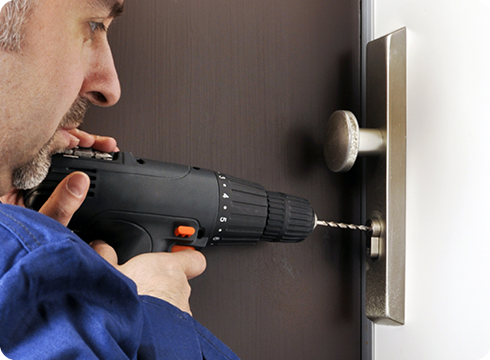 Handwerker mit Werkzeugkoffer vor einem Haus