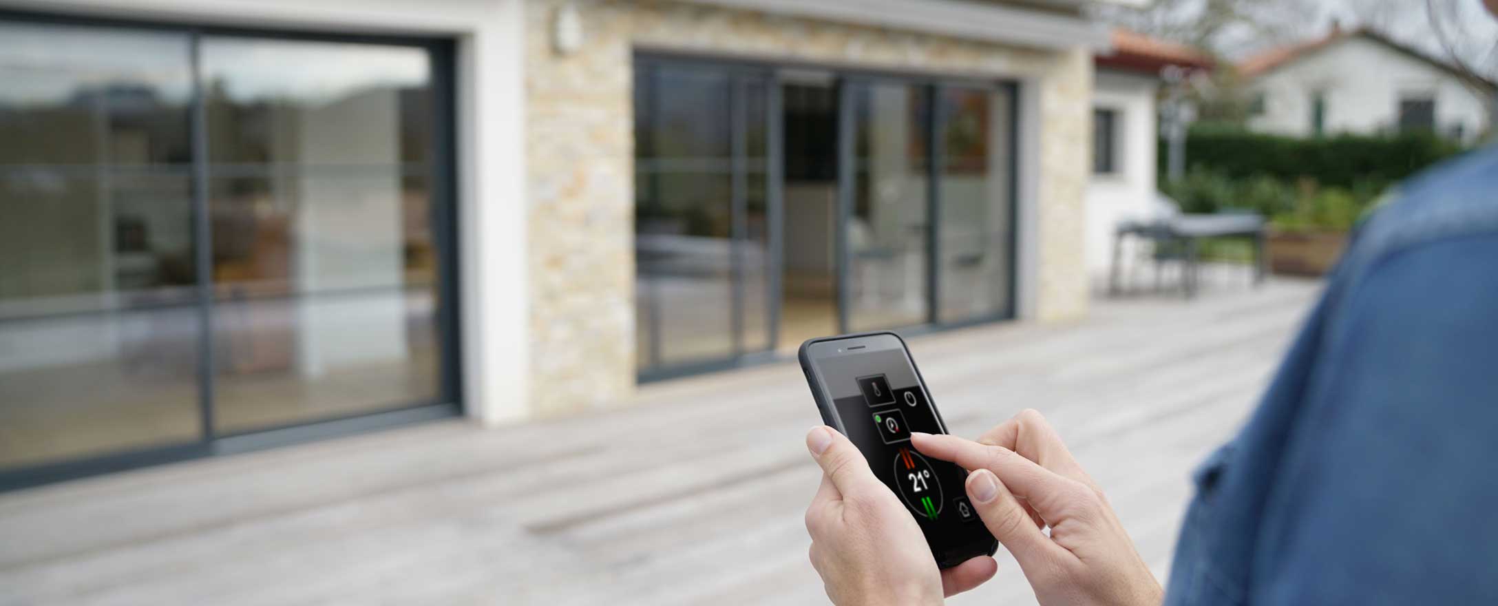 Frau verwendet App für Smart Home vor ihrem Haus